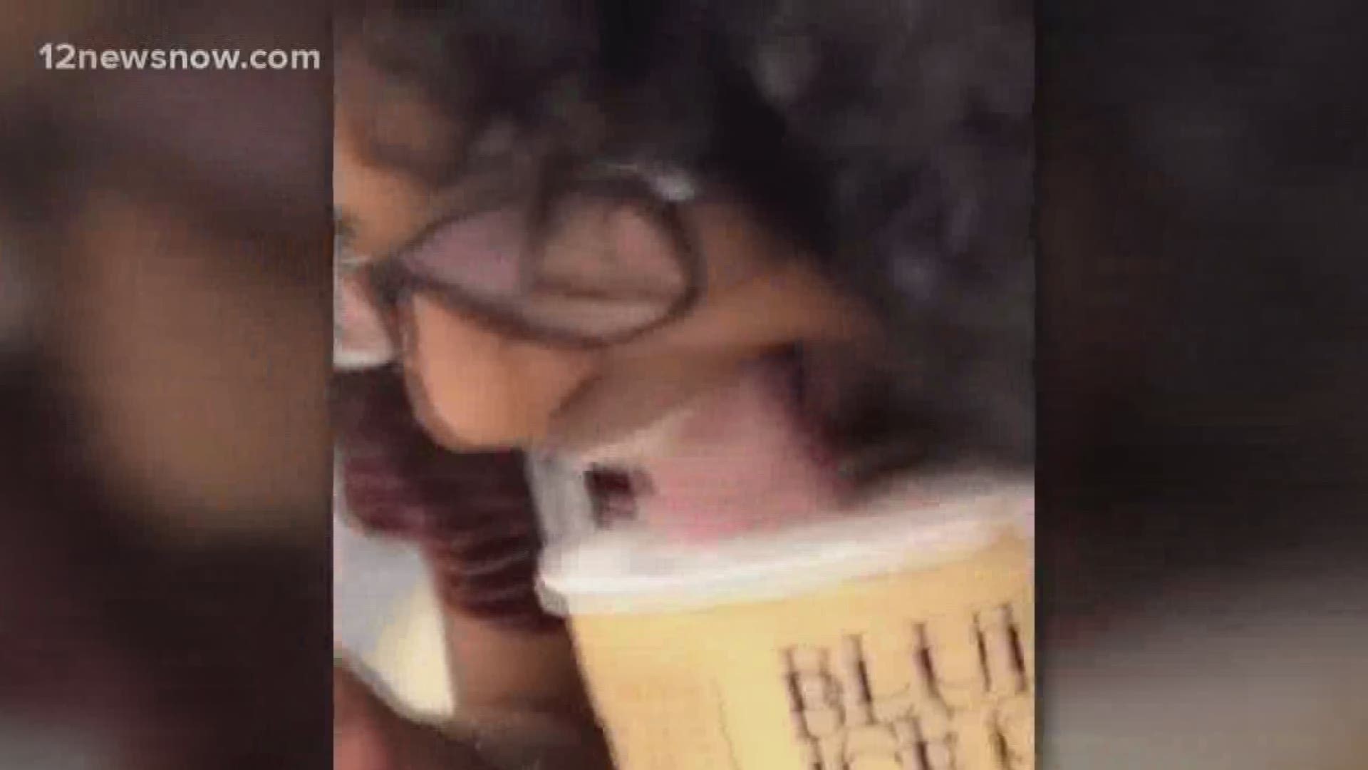 The woman can be seen licking a tub of ice cream and placing it back in the grocery store freezer.