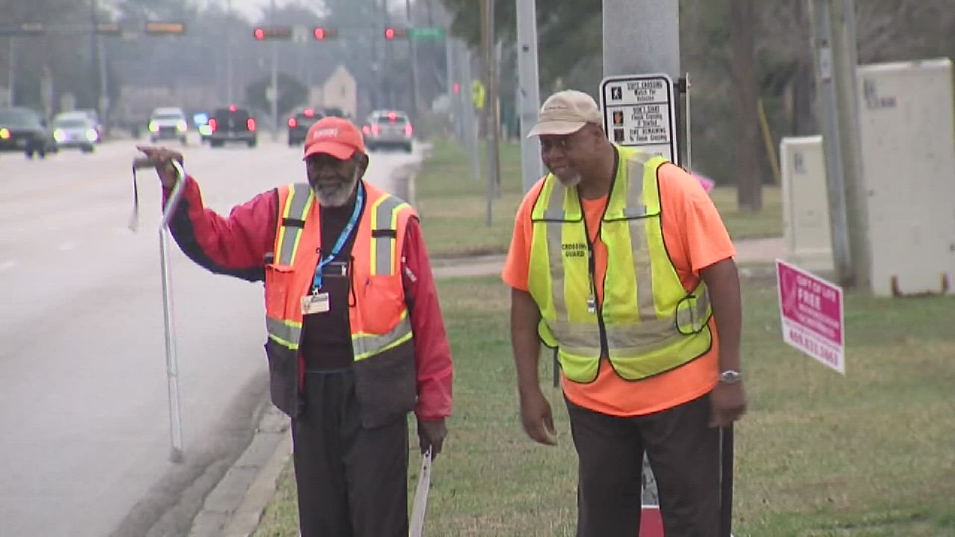 Larry Payne and Bobby Frank like to slow down drivers with their smiles and waves.