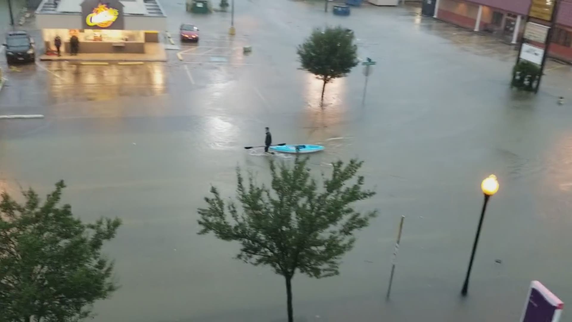 Meteorologist Jeff Gerber catches a man hauling a kayak through flooded streets in Beaumont.