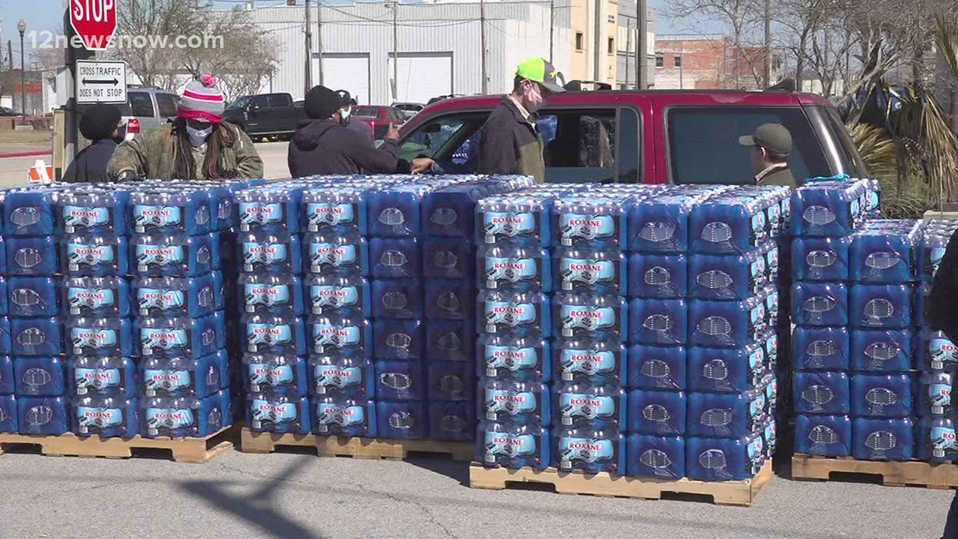 Dozens of cars lined up in downtown Port Arthur to receive bottled water donations.